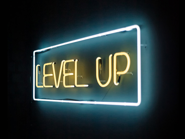 Blue and yellow neon sign spelling out the words "Level up".